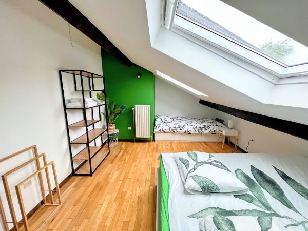 green bedroom with one double and one single bed